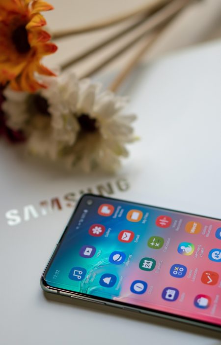 Samsung One UI 8 beta has launched. Picture shows a Samsung mobile phone on a Samsung laptop screen with some flowers in the background