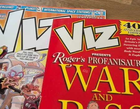 Viz Comic and a copy of Roger's Profanisaurus next to each other on a table for an article showing the problems with Google Live Transcribe