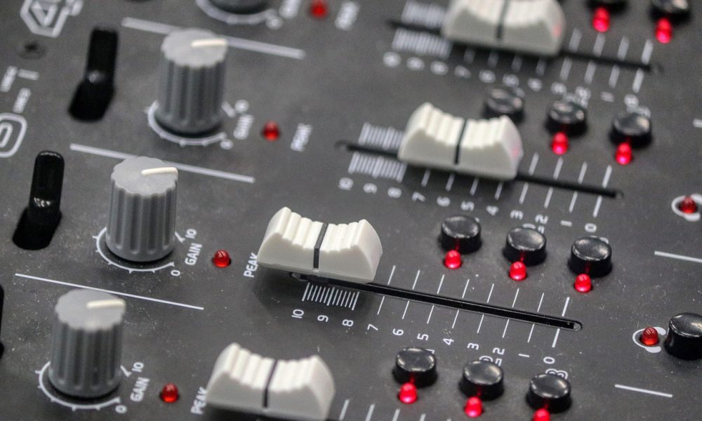 Buttons on a sound desk similar to one used by a sound engineer in a venue that could use Auracast