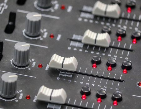 Buttons on a sound desk similar to one used by a sound engineer in a venue that could use Auracast