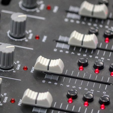 Buttons on a sound desk similar to one used by a sound engineer in a venue that could use Auracast