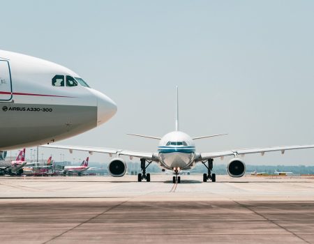 Two airplanes on a runway ready to take off at an unknown airport