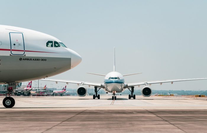 Two airplanes on a runway ready to take off at an unknown airport