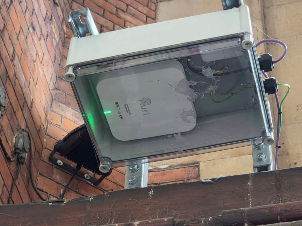 An Auri Auracster box, encased in a box to protect it from the elements, on the wall of Bristol Temple Meads