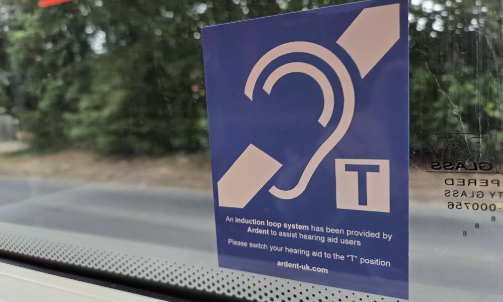 The EFHOH has launched a campaign called Hands Off Our Telecoils. A telecoil sign on a bus