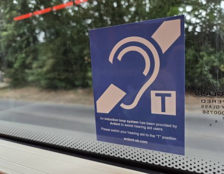 The EFHOH has launched a campaign called Hands Off Our Telecoils. A telecoil sign on a bus