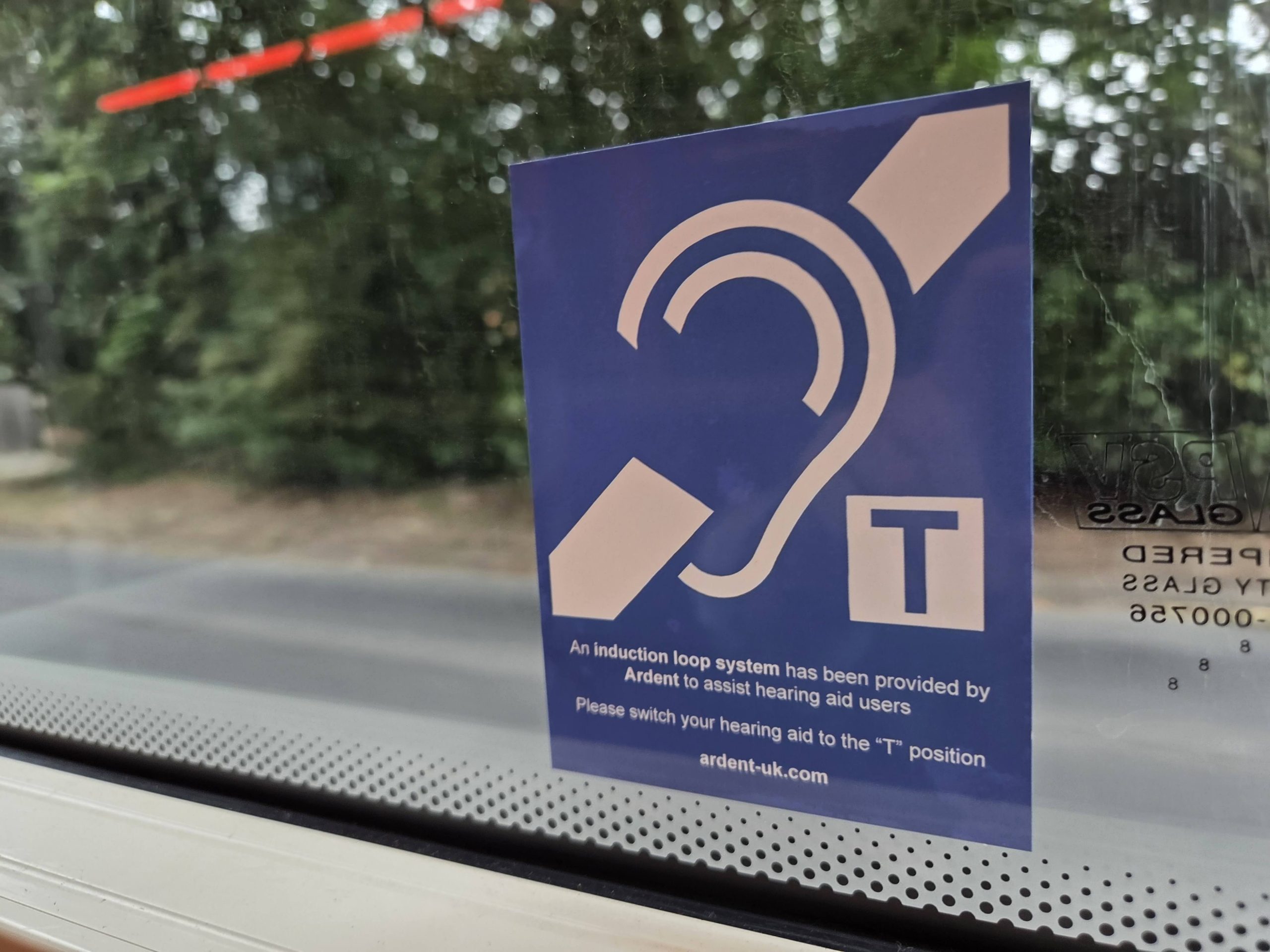 The EFHOH has launched a campaign called Hands Off Our Telecoils. A telecoil sign on a bus