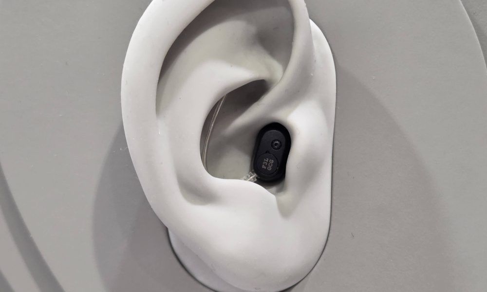 EUHA 2025: Oticon Zeal powers up with Auracast and next gen AI The Oticon Zeal on display at EUHA - it is situated in a 3D mock-up of an ear