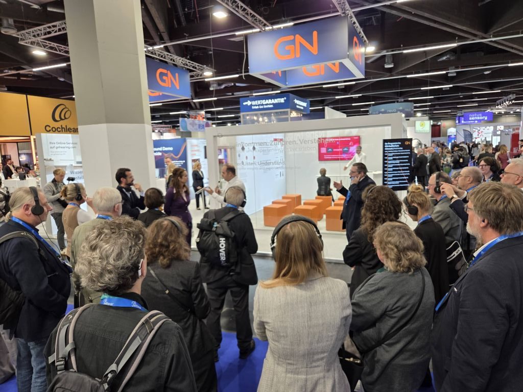 A group of people standing around the GN stall at EUHA