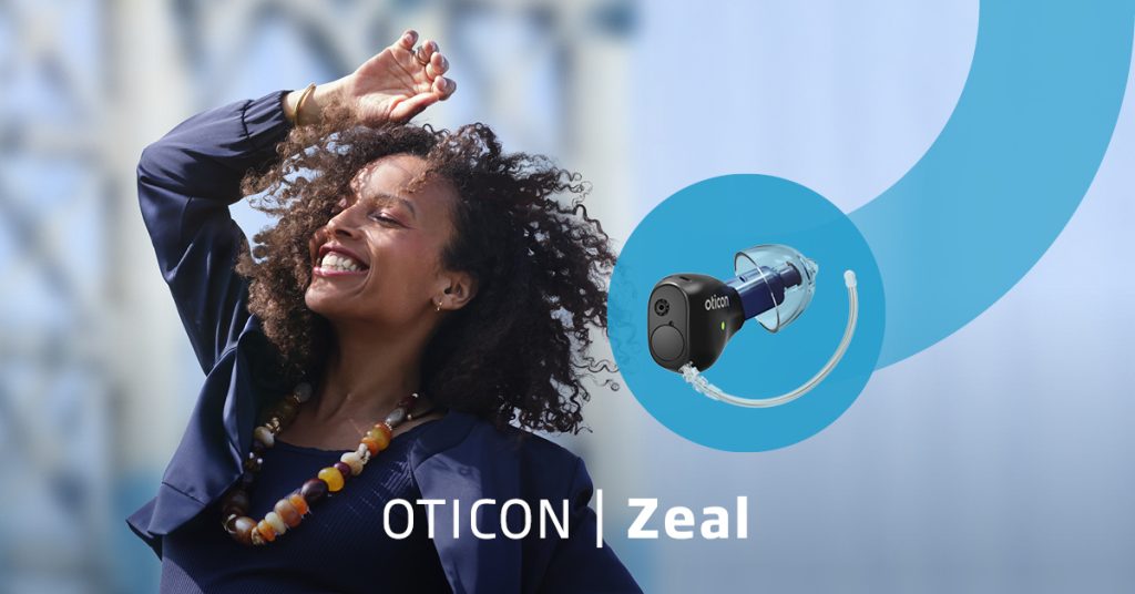 Oticon launch picture for Oticon Zeal featuring a happy woman dancing with her hand in the air. In a blue swoosh is a picture of the Oticon Zeal which comes with Google Fast Pair