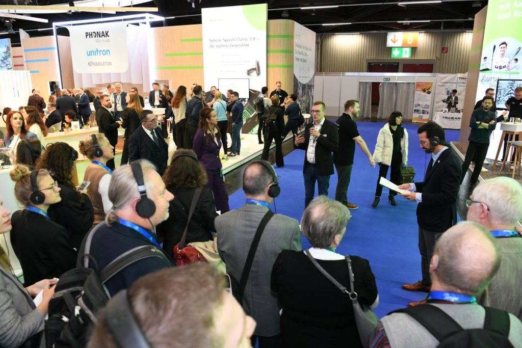 People wearing headphones and listening to an Auracast at the EUHA Congress