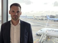 Johannes Sittig looking at the camera, with aeroplanes behind him