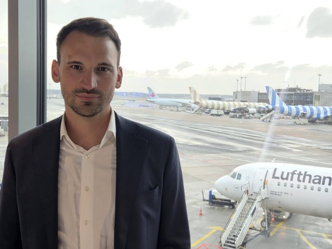 Johannes Sittig looking at the camera, with aeroplanes behind him