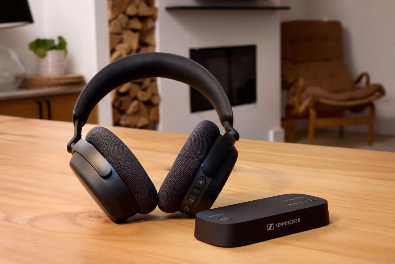 the Sennheiser RS 275 TV Headphones and BTA1 TV Transmitter sitting next to each other in a wooden table