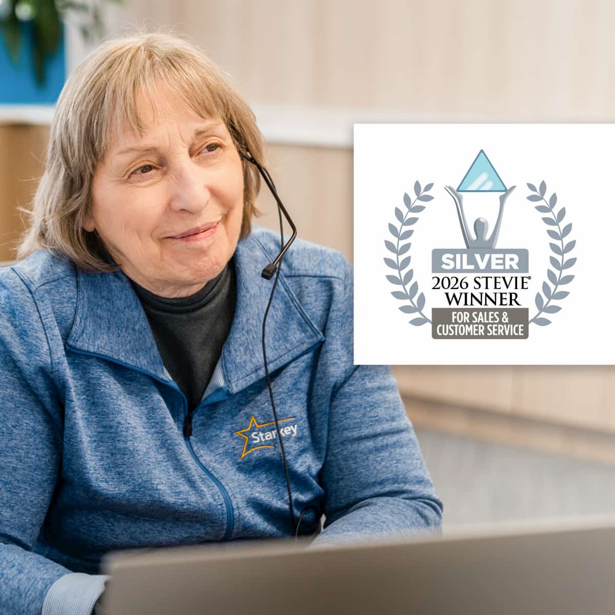 A Starkey customer service representative wearing a blue top and a headset. Next to it is the logo for the Stevie Awards, given for the hearing aid firm's customer service